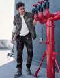 Man working on red pipes against a blue wall