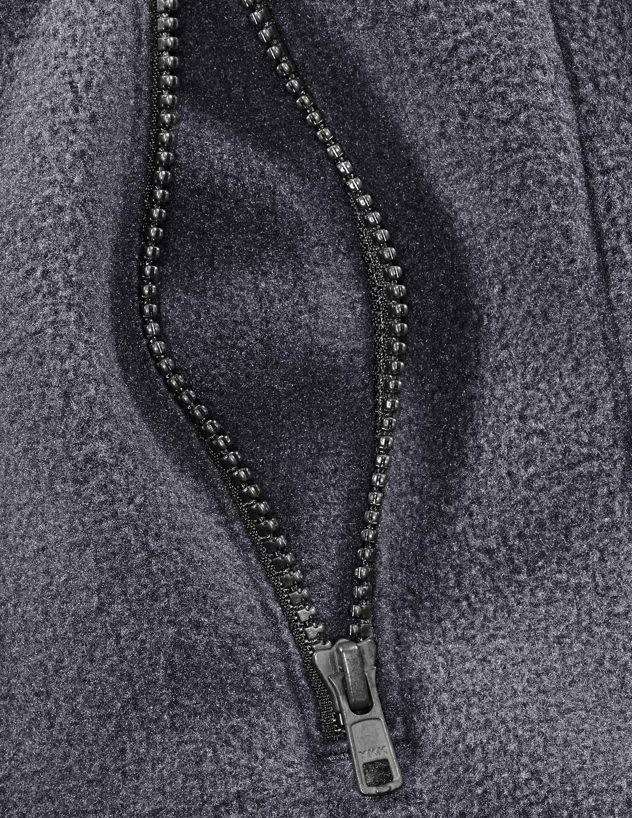 Close-up of a zipper on a textured gray fabric background