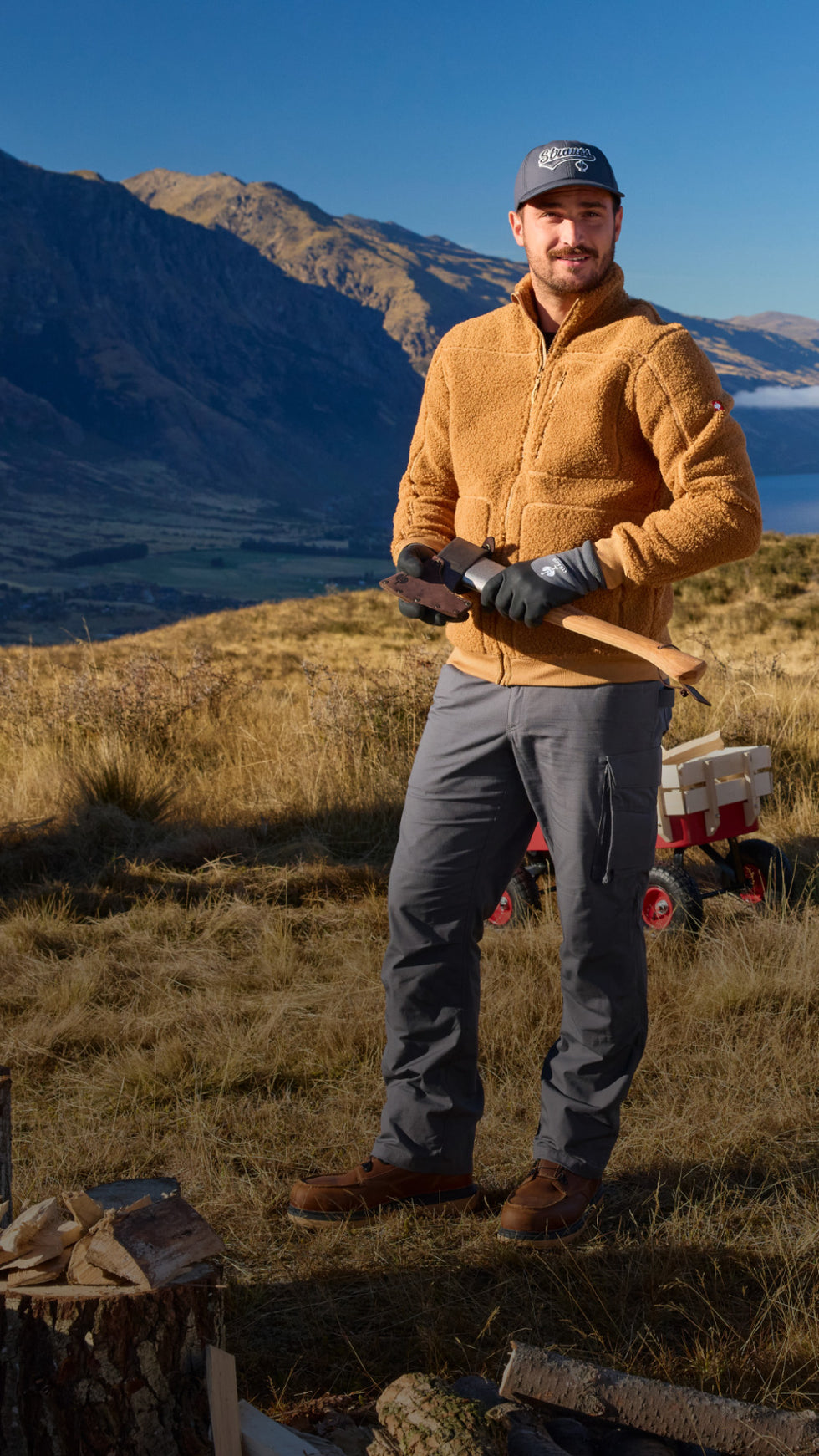 Man in outdoor setting with mountains and a lake in the background