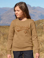 Child wearing a brown sweatshirt with 'Strauss' logo in a mountainous landscape