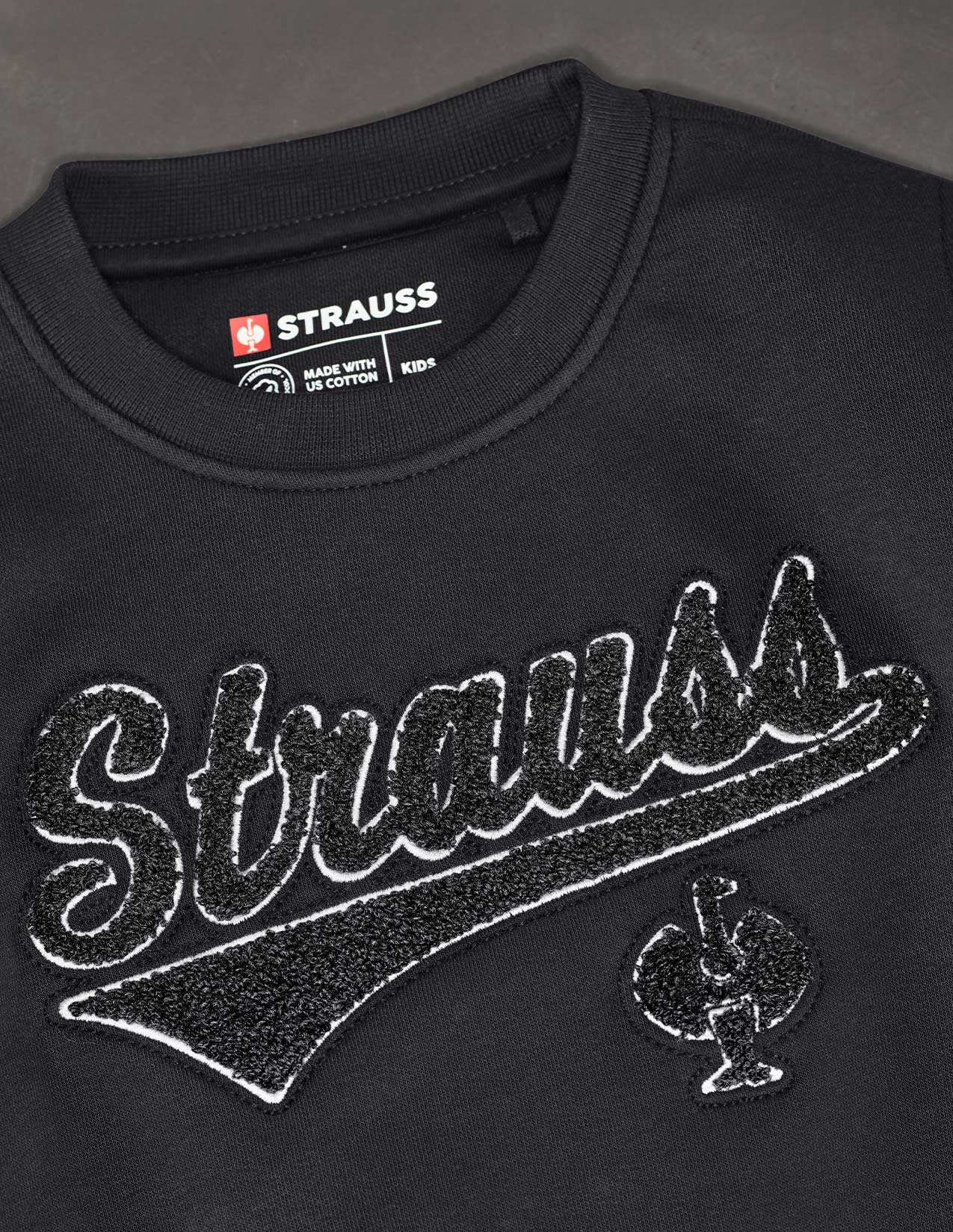 Black Strauss sweatshirt with logo and text on a dark background