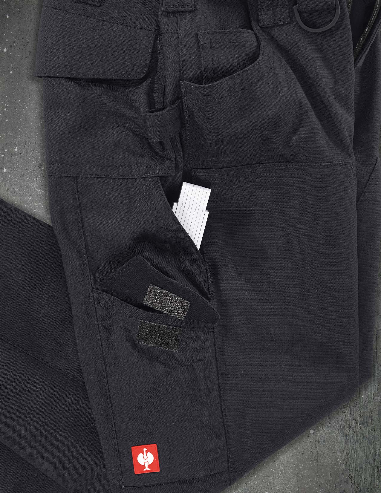Black pants with a brand logo on a gray background