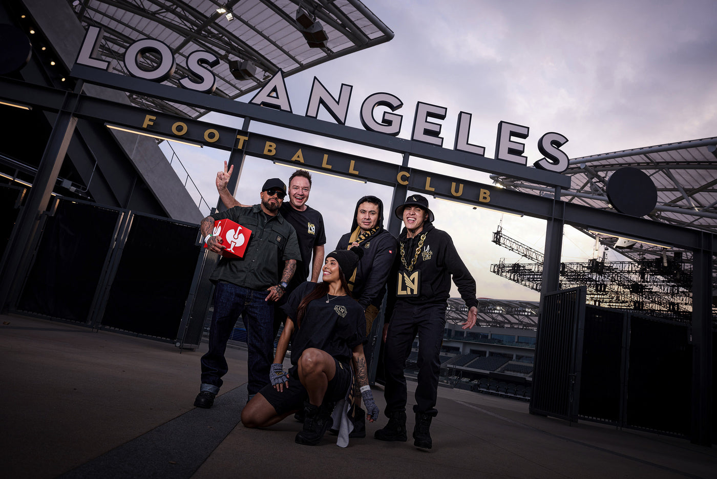Group of people posing in front of a Los Angeles Football Club sign.