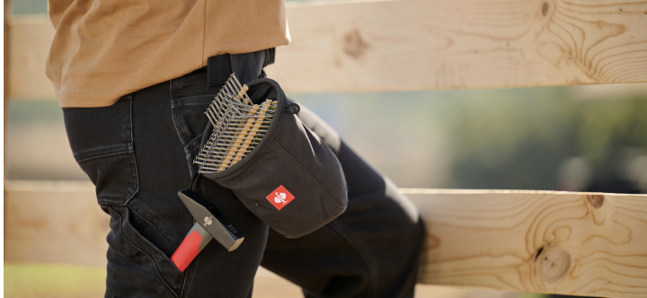 A close-up view shows a person wearing black work pants with a small tool pouch attached to the belt holding brushes and hand tools.