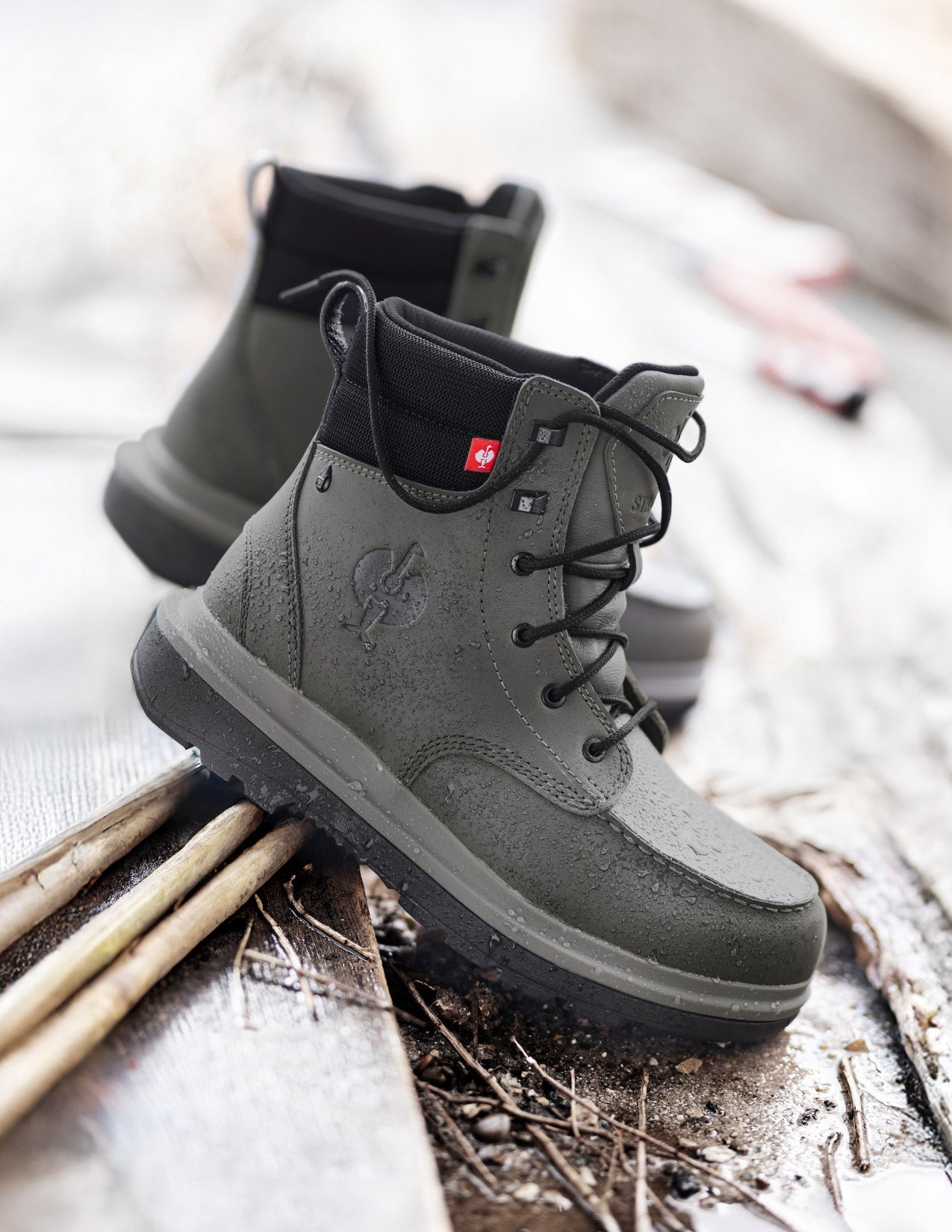 Gray boots with a brand logo on a wooden surface