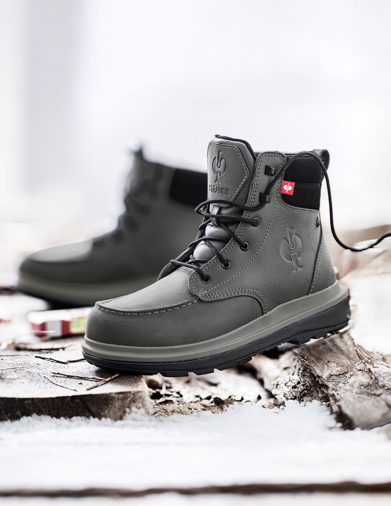Gray hiking boots on a wooden log with a snowy background