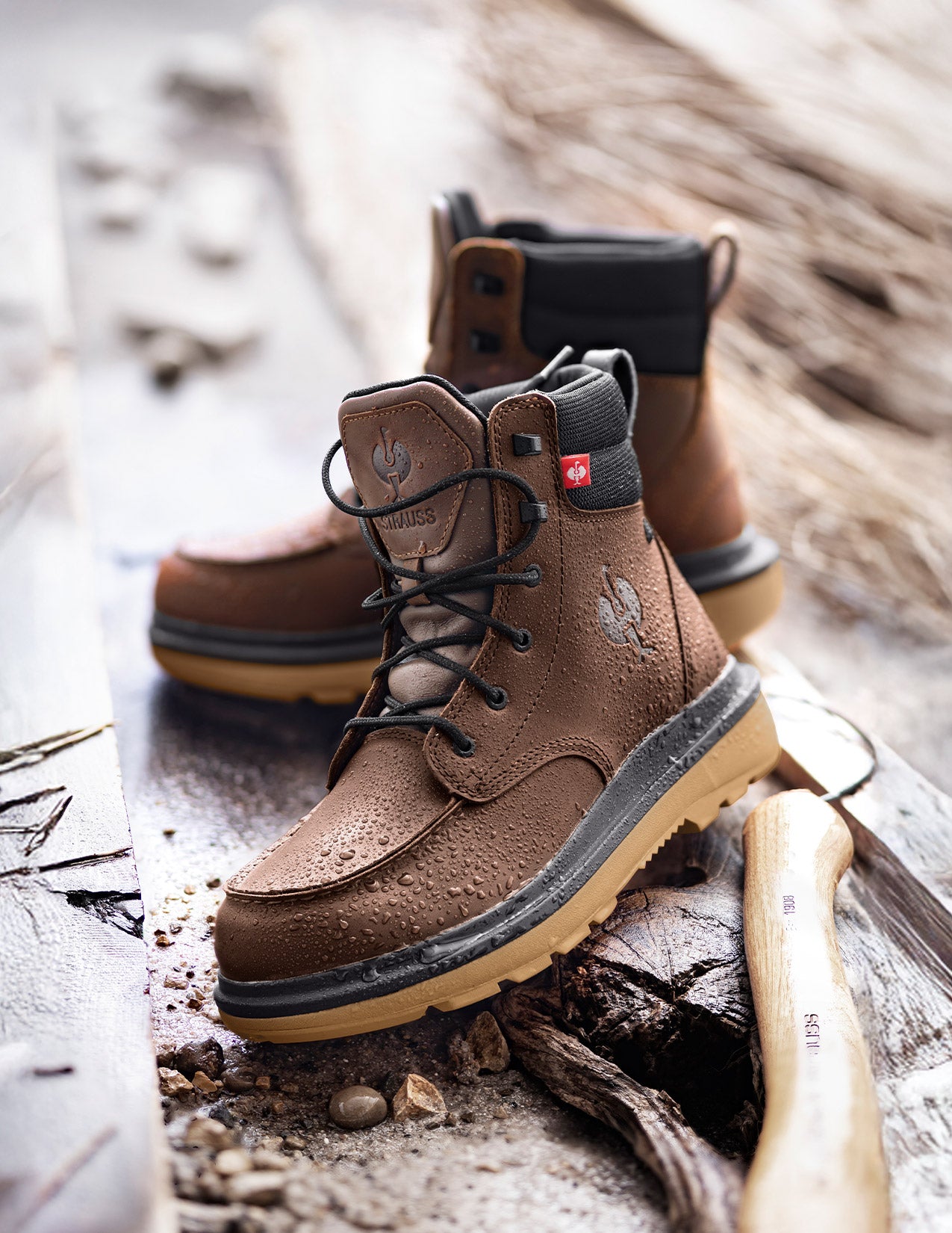 Brown work boots with black soles on a wooden surface