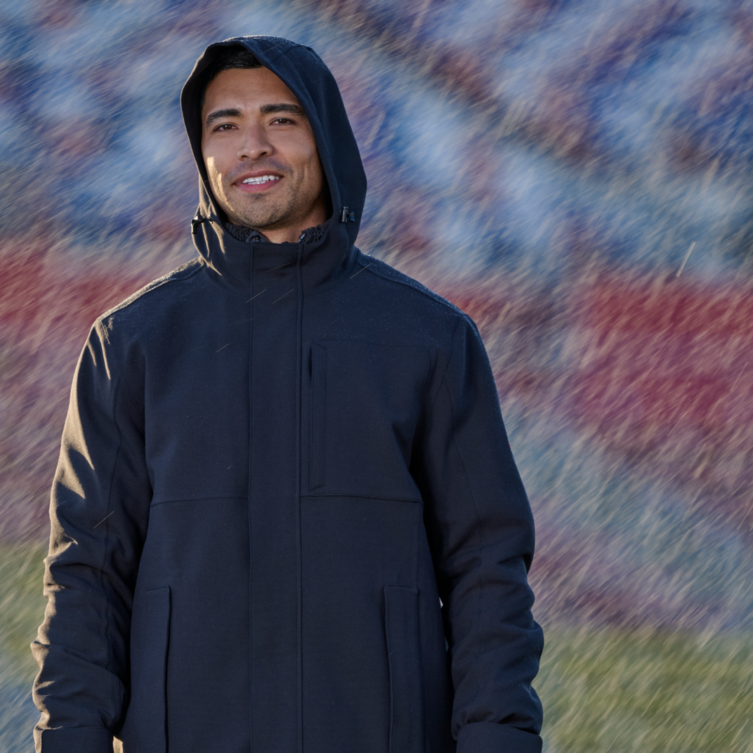 Man wearing a dark blue hooded jacket standing in the rain