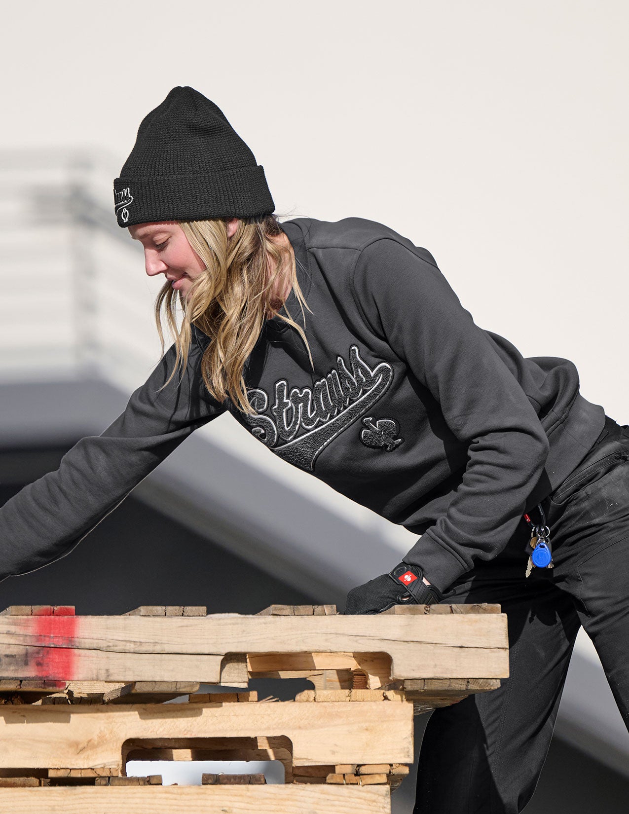 Person in winter clothing pushing a pallet.