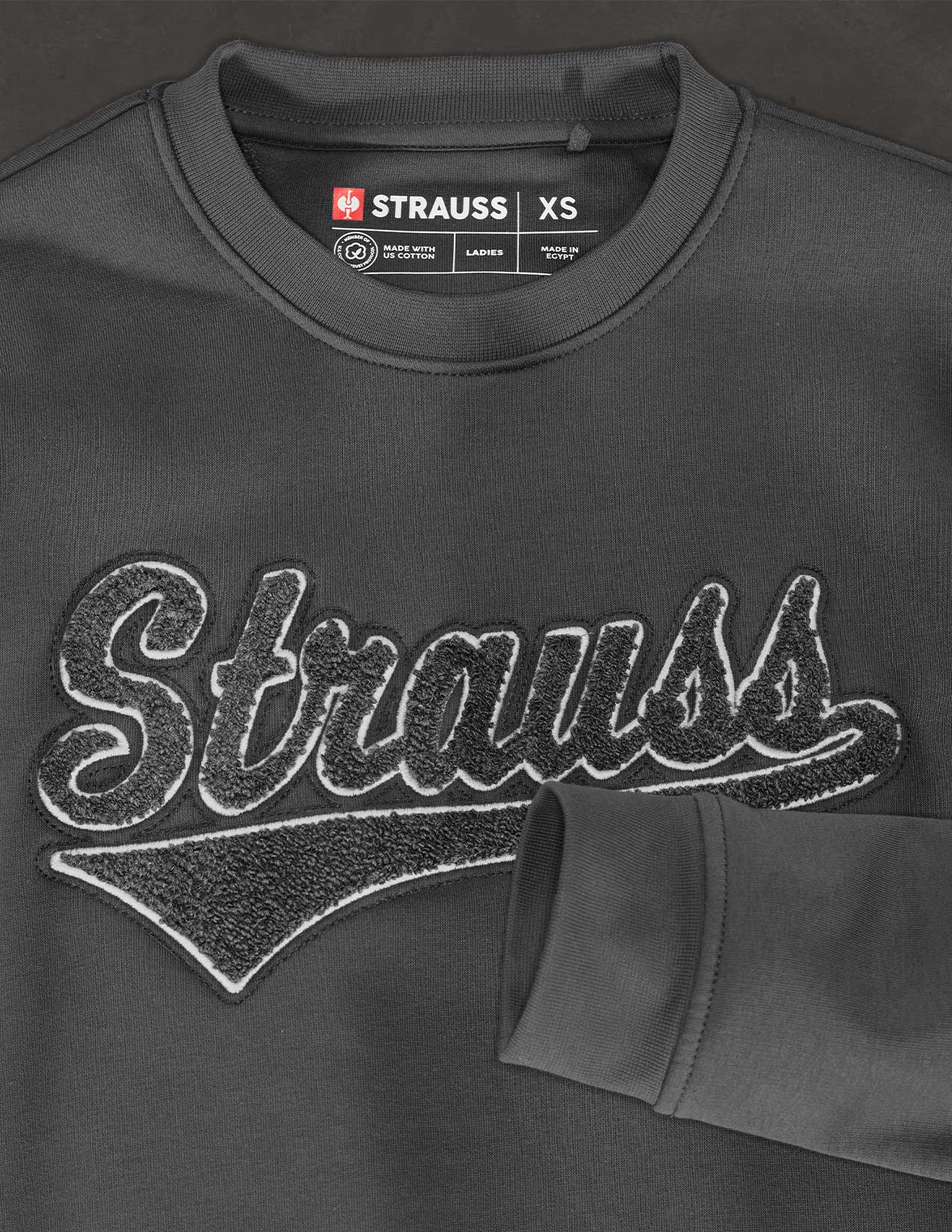 Dark gray sweatshirt with 'Strauss' branding on a dark background