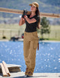 Person carrying wooden planks by a body of water