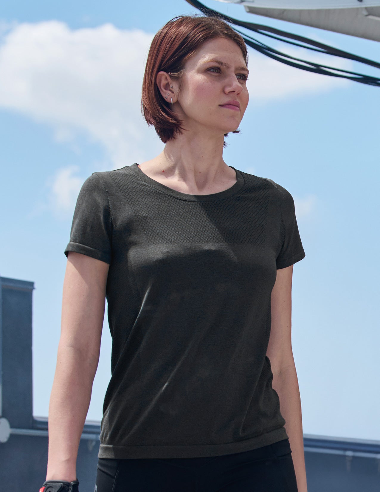 Woman wearing a black and gray t-shirt with a clear blue sky background