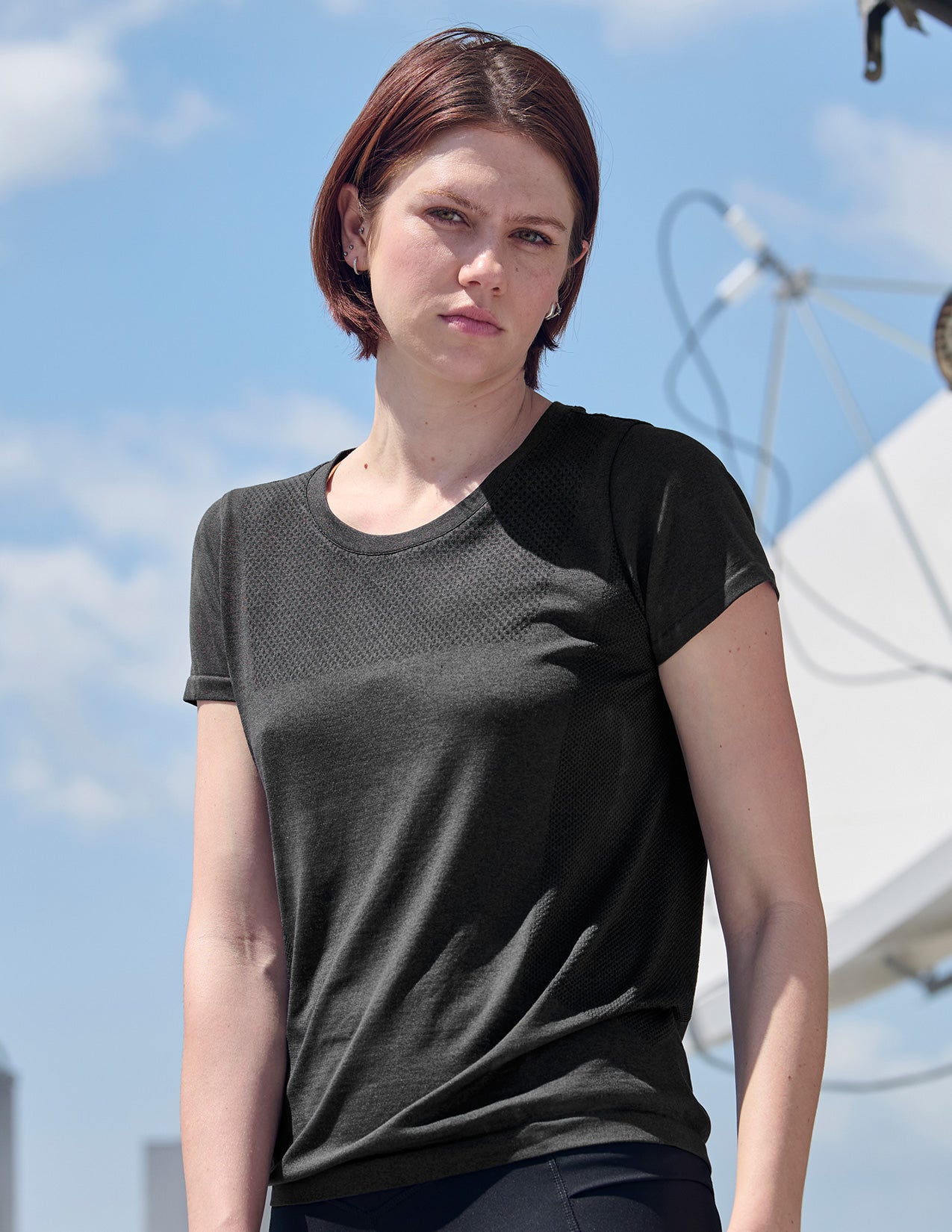 Woman wearing a black and gray t-shirt with a blue sky background