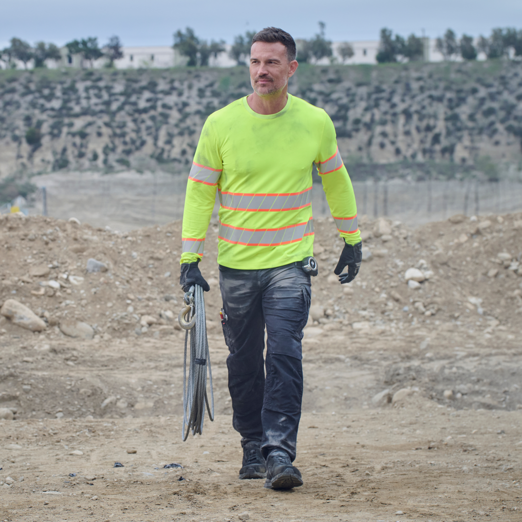 Man in high-visibility safety gear walking on a construction site