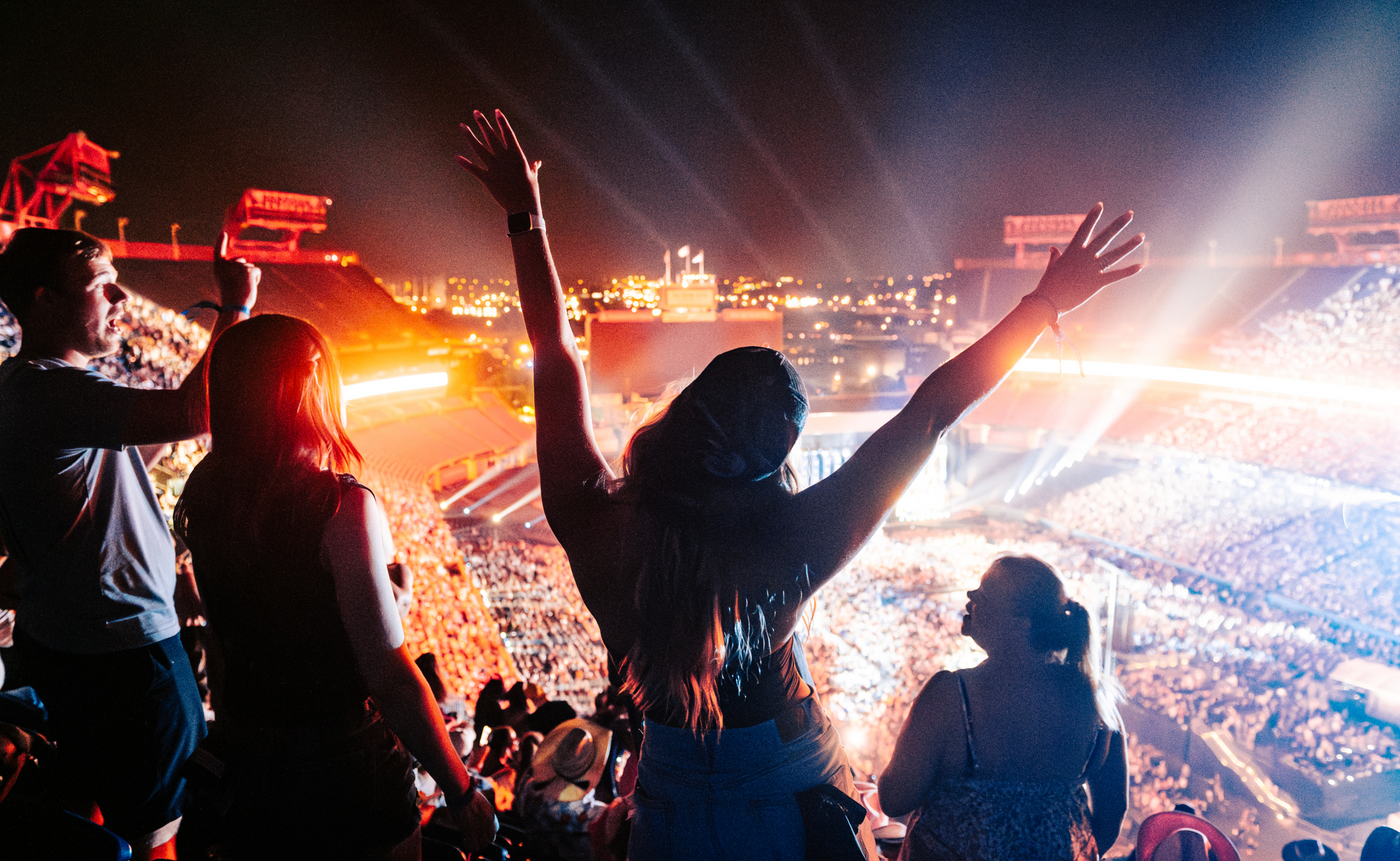 a woman raising her hands, dancing to the music