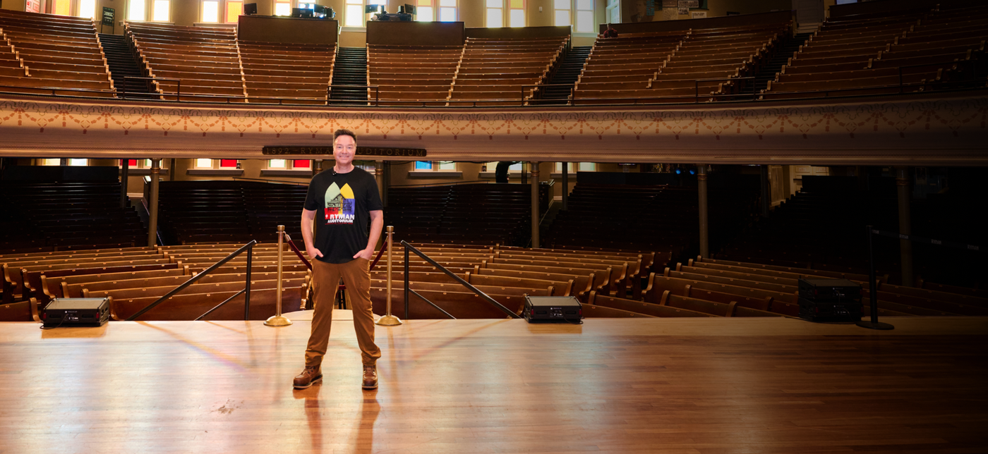 A picture of Henning Strauss standing on the stage at the Ryman Auditorium