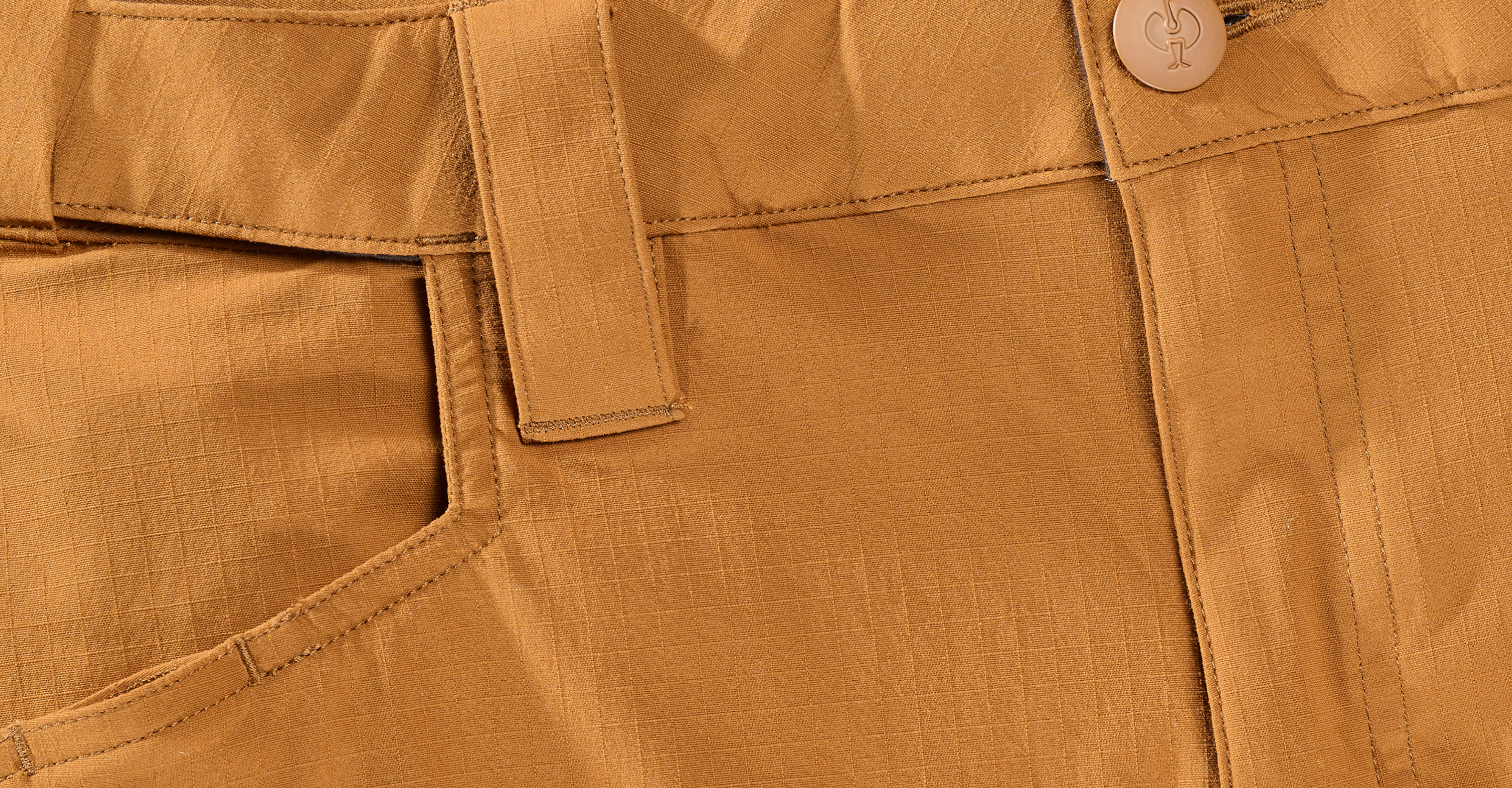 Close-up of light brown pants showing the waistband, belt loop, pocket, button, and visible stitching details on the ripstop fabric.