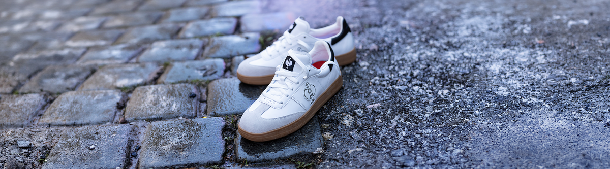 A pair of Brooklyn Safety Sneakers standing on a wet asphalt ground