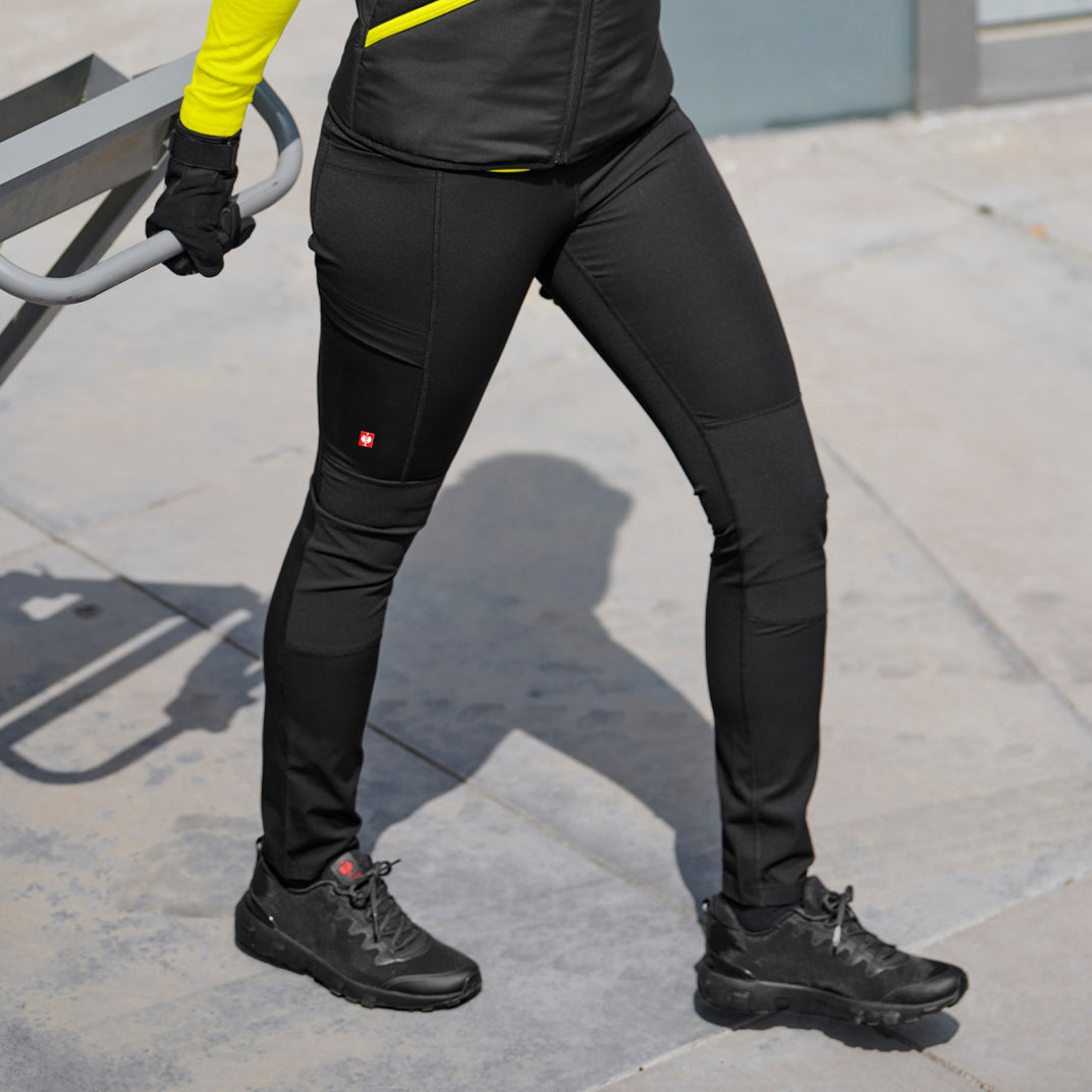 Person wearing black leggings on a sidewalk.