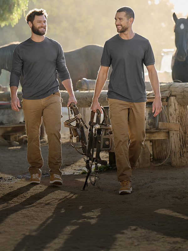 Two men walk on a ranch in strauss workwear