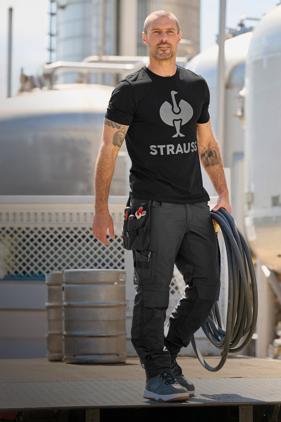 Man carries hose in a factory