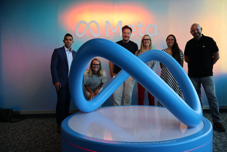 STRAUSS and Meta teams in front of logo statue.