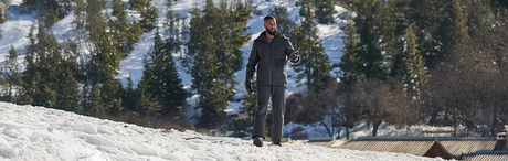 a man standing in the snow, wearing winter workwear