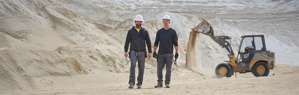 Two men at the construction site wearing workwear