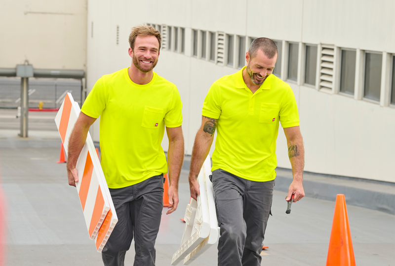 Two men in high visibility shirts on a construction site