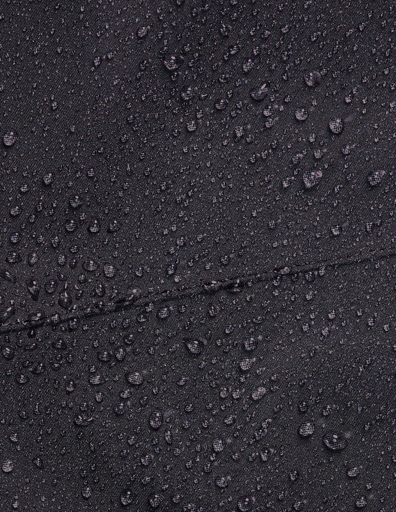 Close-up of water droplets on a black surface.