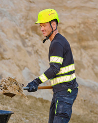 A bright yellow STRAUSS Baseball Style Hard Hat with a visor on a model digging sand on a construction site.