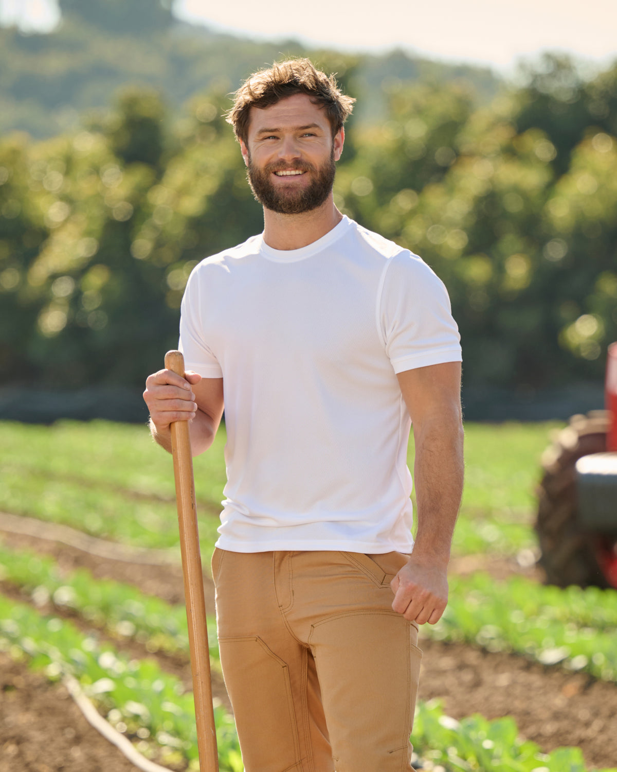 A worker wears the STRAUSS Performance T-Shirt in white with tan work pants on a sunny jobsite