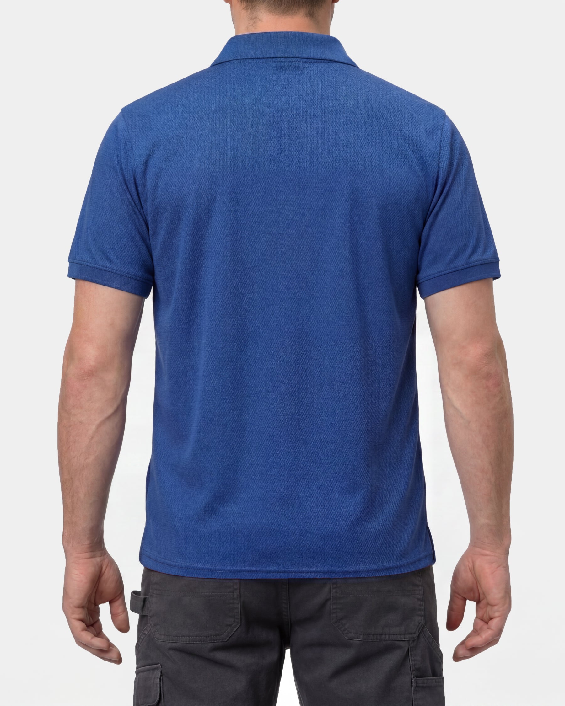 A model wears the STRAUSS Performance Polo Shirt in royal blue with tan work pants and work boots, showing the shirt fit