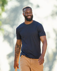 A worker wears the STRAUSS Performance T-Shirt in nero blue on a sunny jobsite