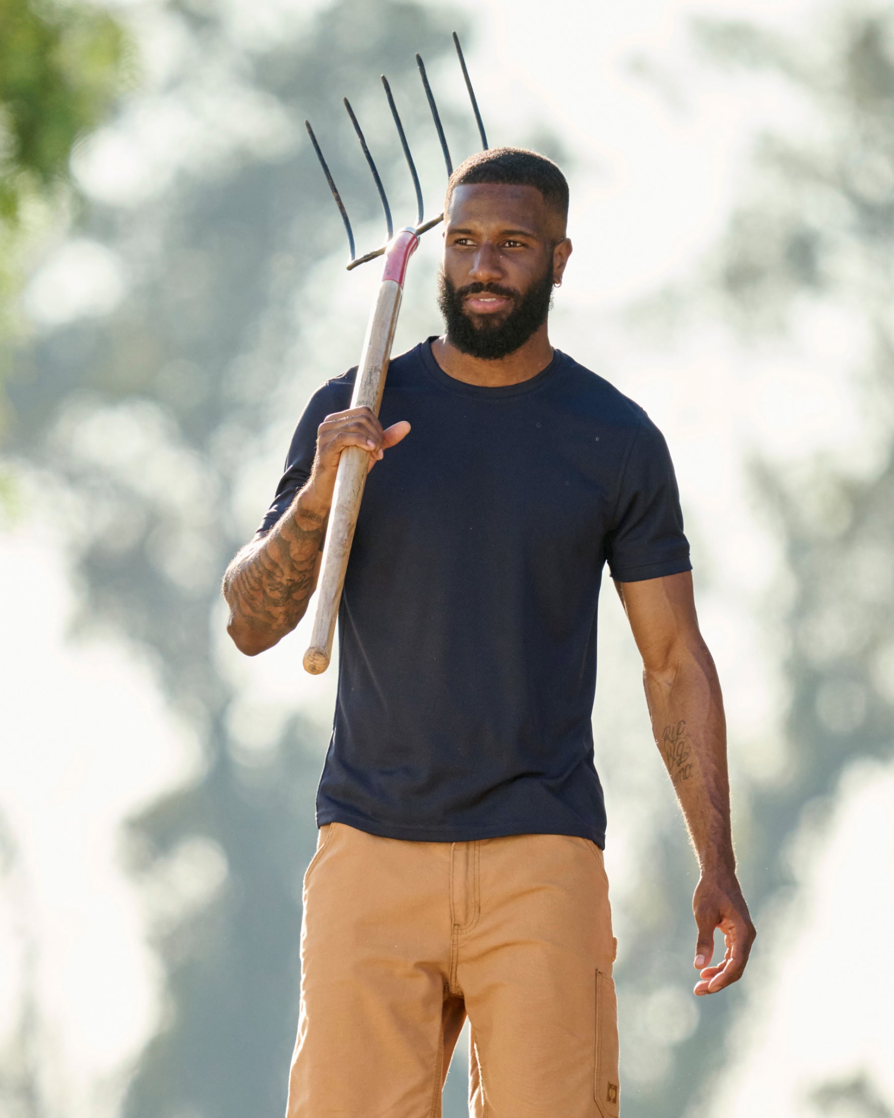 A worker wears the STRAUSS Performance T-Shirt in nero blue while working in a field