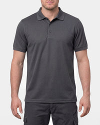 A model wears the STRAUSS Performance Polo Shirt in carbon gray in a studio product scene