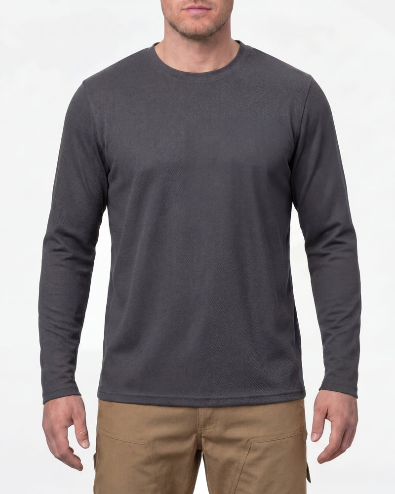 A model wears the STRAUSS Performance Long Sleeve Shirt in carbon gray with tan work pants and work boots in a studio product scene