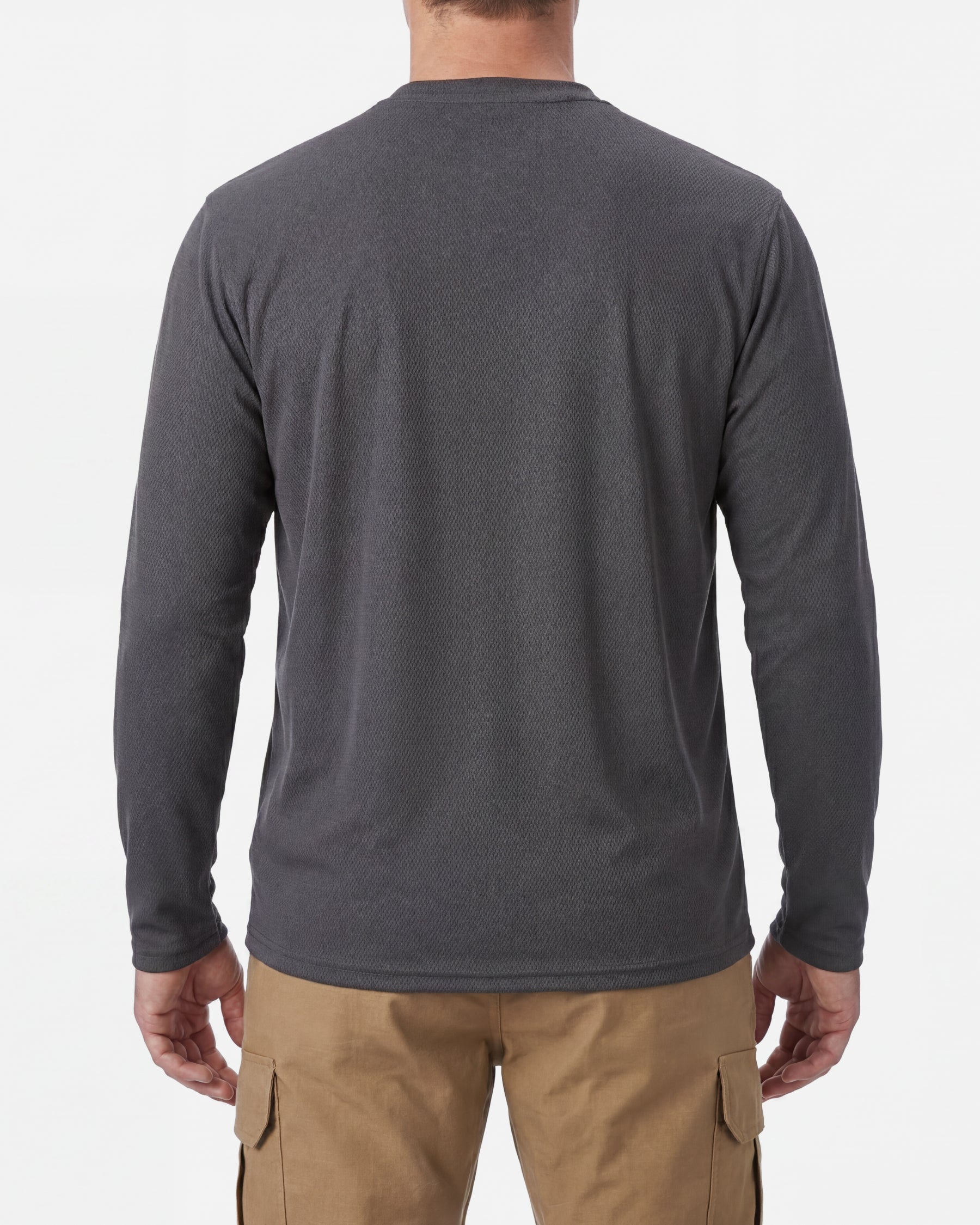 A model wears the STRAUSS Performance Long Sleeve Shirt in carbon gray with tan work pants and work boots, showing the shirt fit