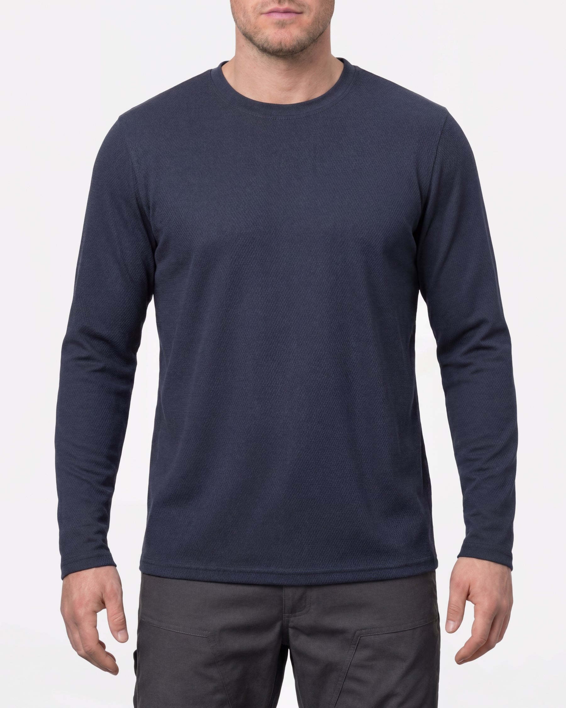 A model wears the STRAUSS Performance Long Sleeve Shirt in nero blue with tan work pants and work boots in a studio product scene