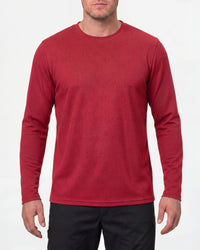 A model wears the STRAUSS Performance Long Sleeve Shirt in fire red with tan work pants and work boots in a studio product scene
