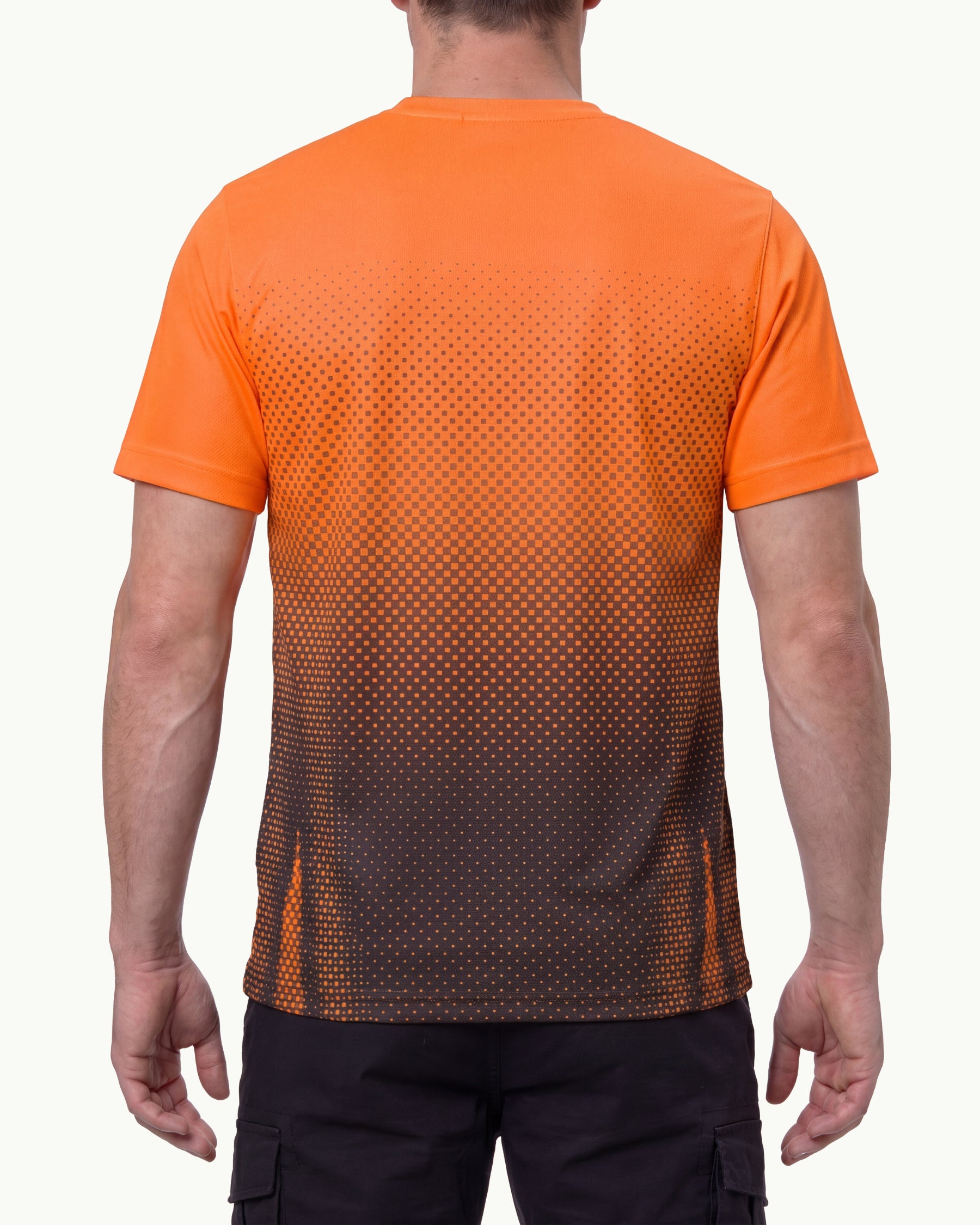 A model wears the STRAUSS Enhanced Visibility Performance T-Shirt e.s.t:aktik in neon orange and black with black work pants in a high-visibility workwear outfit, showing the shirt fit