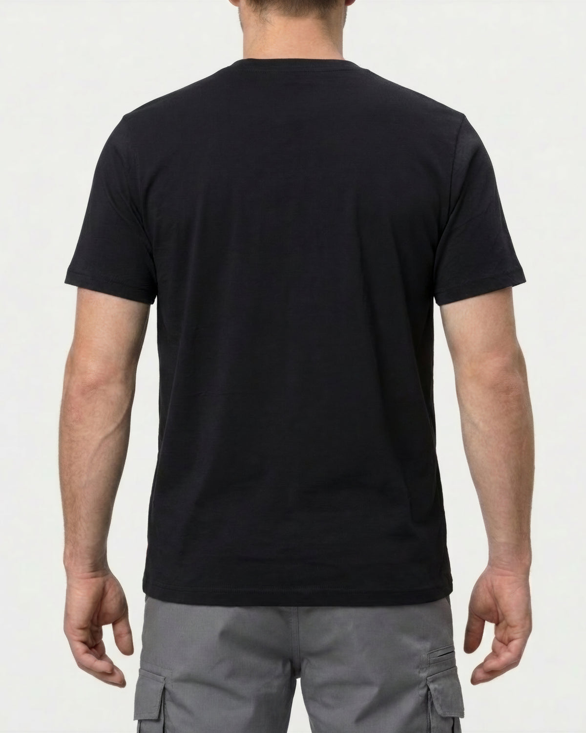 A model wears the STRAUSS Pocket T-Shirt e.s.iconic in black with work pants and work boots, showing the shirt fit