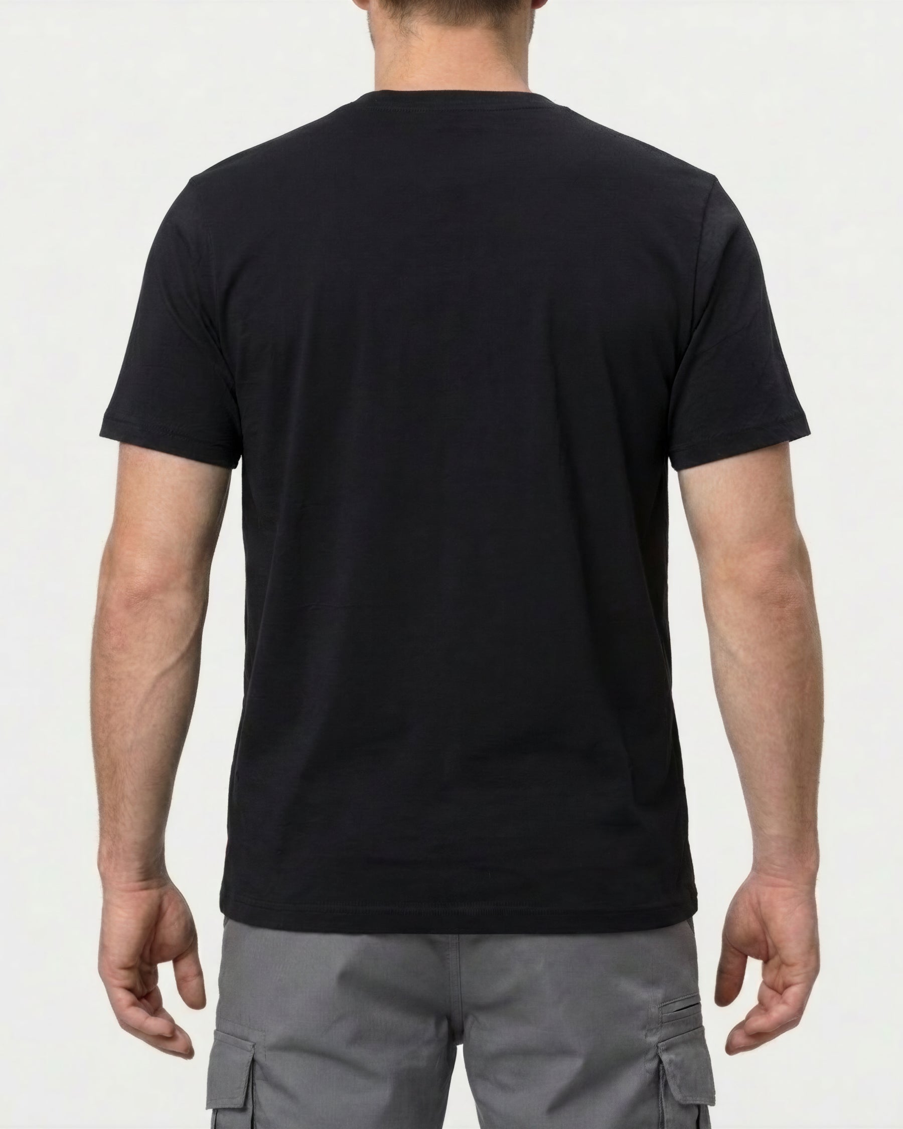 A model wears the STRAUSS Pocket T-Shirt e.s.iconic in black with work pants and work boots, showing the shirt fit