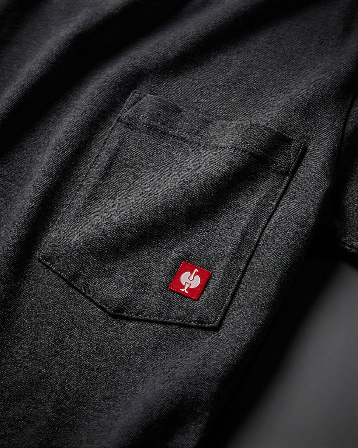 Close-up of the black STRAUSS Pocket T-Shirt e.s.iconic chest pocket with STRAUSS ostrich logo