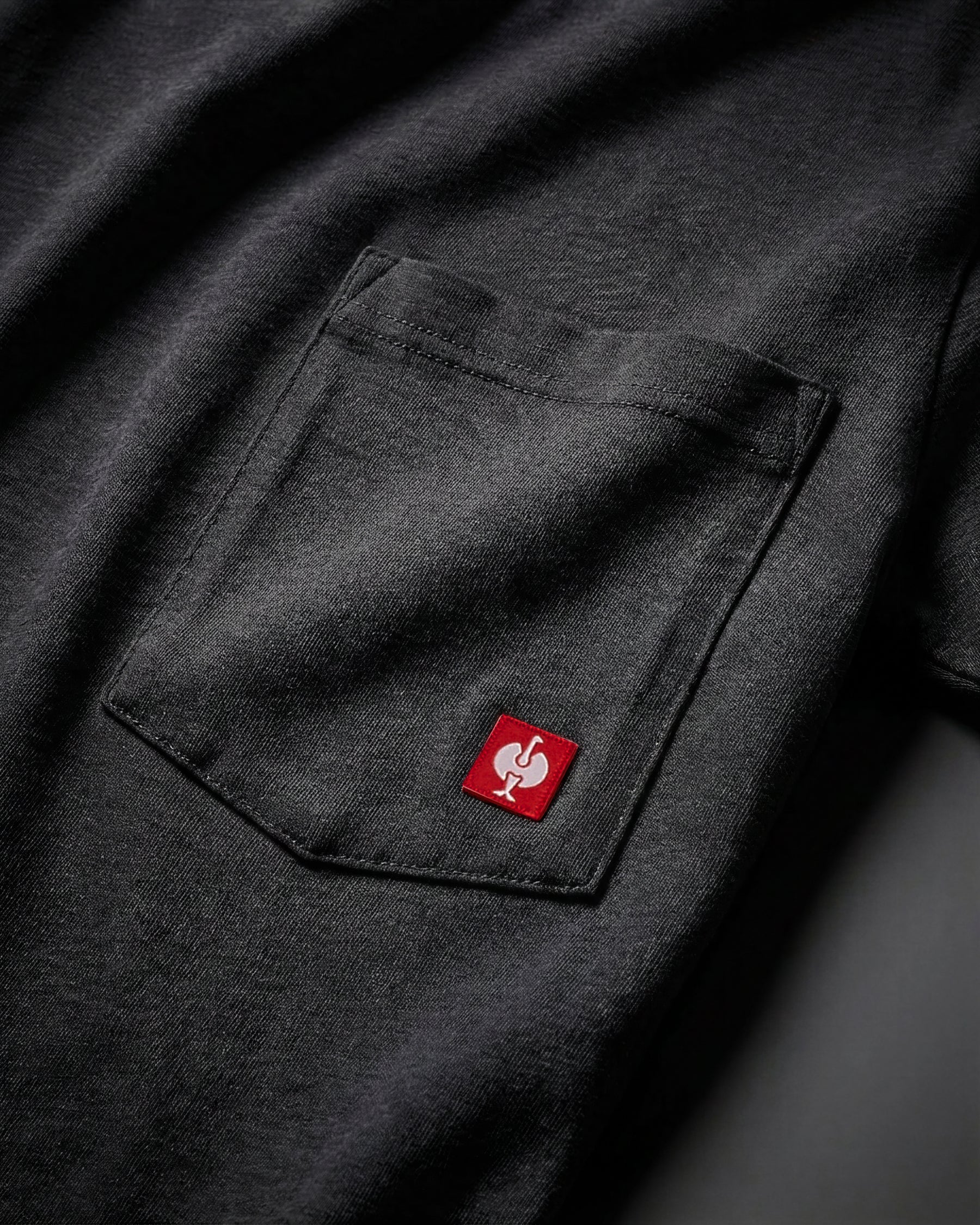 Close-up of the black STRAUSS Pocket T-Shirt e.s.iconic chest pocket with STRAUSS ostrich logo