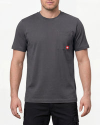 A model wears the STRAUSS Pocket T-Shirt e.s.iconic in carbon gray with work pants and work boots in a studio product scene