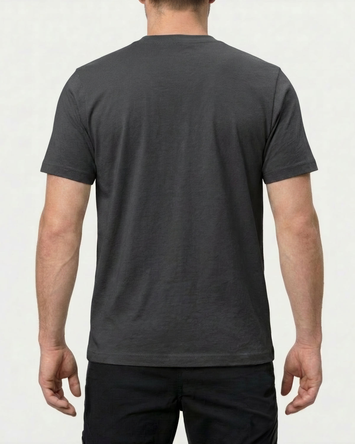 A model wears the STRAUSS Pocket T-Shirt e.s.iconic in carbon gray with work pants and work boots, showing the shirt fit