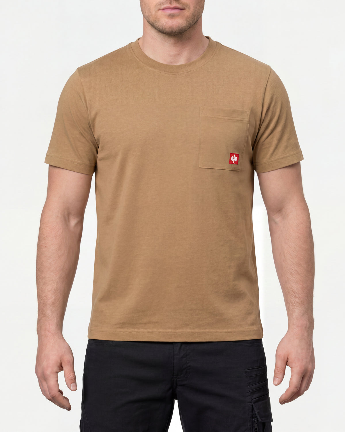 A model wears the STRAUSS Pocket T-Shirt e.s.iconic in almond brown with work pants and work boots in a studio product scene