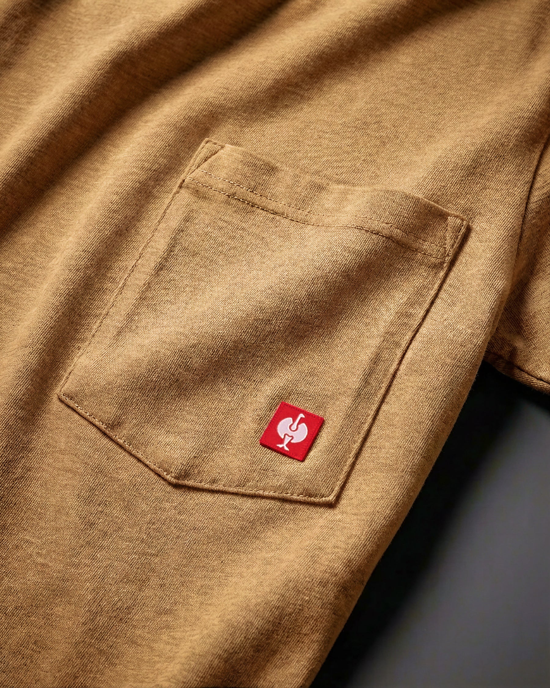 Close-up of the almond brown STRAUSS Pocket T-Shirt e.s.iconic chest pocket with STRAUSS ostrich logo