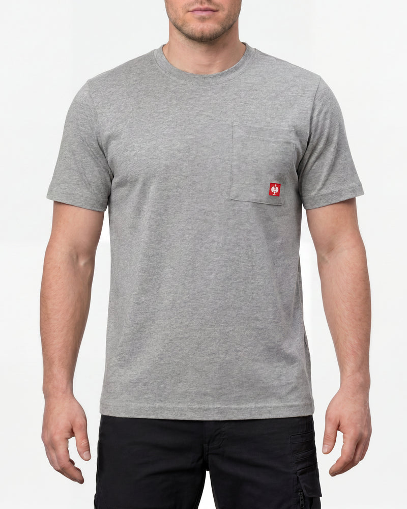 A model wears the STRAUSS Pocket T-Shirt e.s.iconic in gray melange with work pants and work boots in a studio product scene